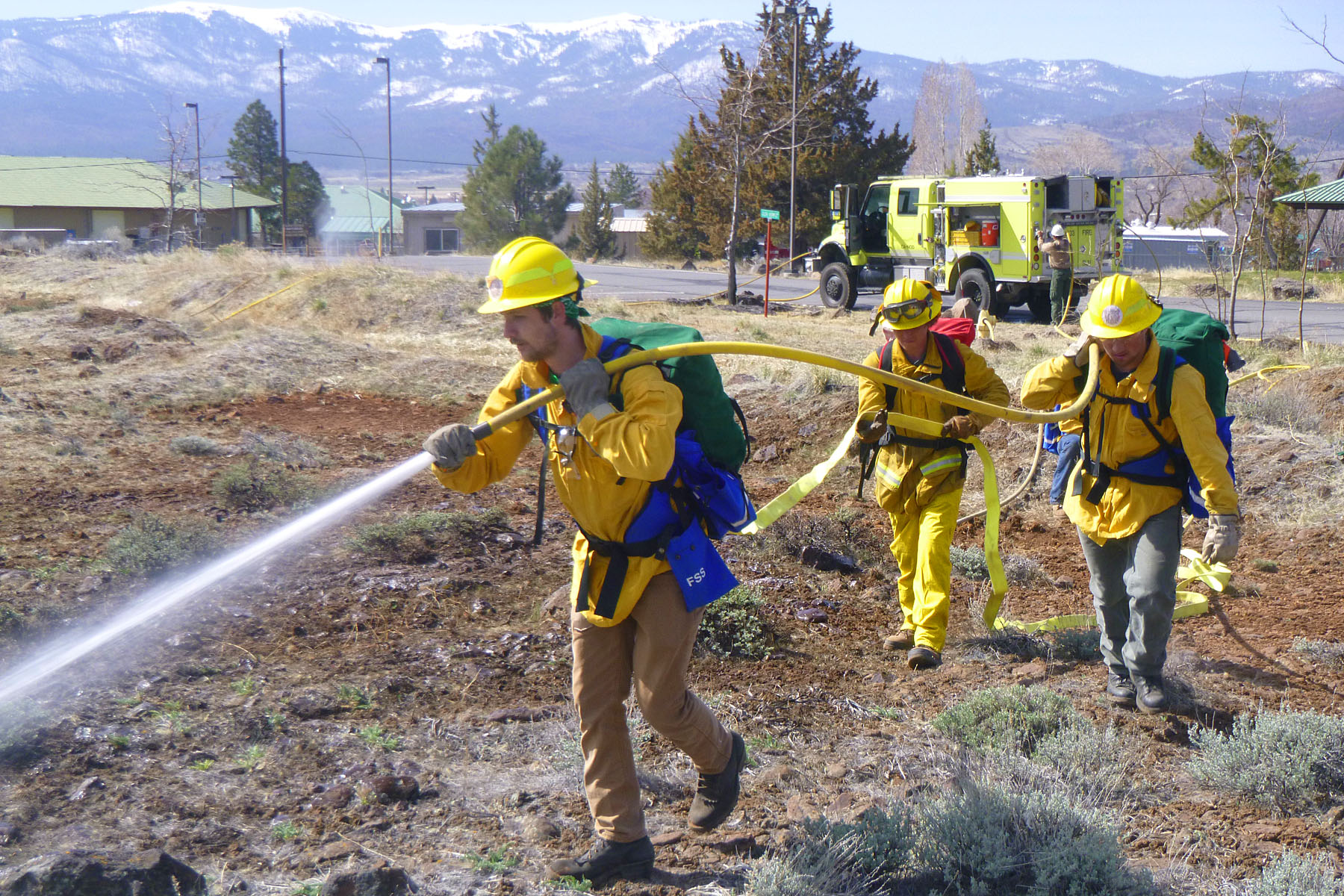 fire tech students pulling hose in field